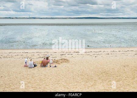 Southend - une famille de vous détendre sur la plage à Thorney Bay sur Southend, Essex. Banque D'Images