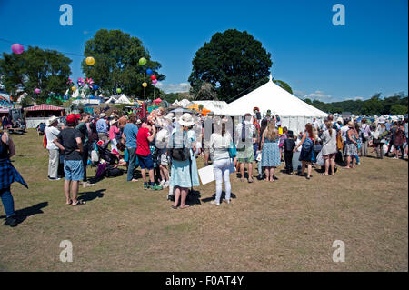 La foule des familles se réunir autour d'un interprète dans le soleil d'été au Port Eliot Cornwall Festival Banque D'Images