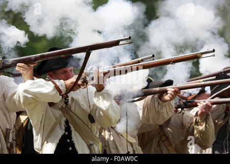 Les soldats de l'armée continentale pendant la guerre révolutionnaire mousquets tirant au creux de reconstitution Jockey au parc historique national de Morristown, New Jersey, USA Banque D'Images