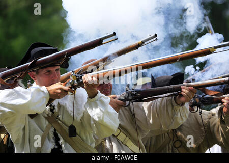 Les soldats de l'armée continentale pendant la guerre révolutionnaire mousquets tirant au creux de reconstitution Jockey au parc historique national de Morristown, New Jersey, USA Banque D'Images