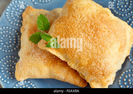 Pâte feuilletée sucrée avec du sucre et de la menthe close up sur plaque bleue Banque D'Images