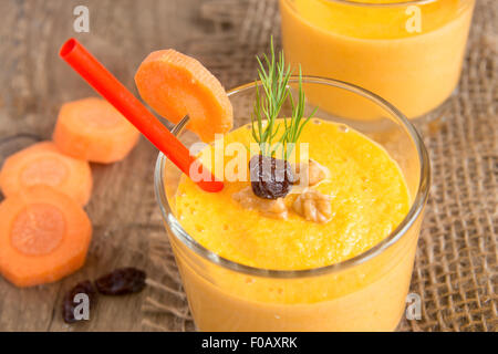 Smoothie aux carottes et aux noix et aux raisins sur fond de bois horizontal, Close up Banque D'Images