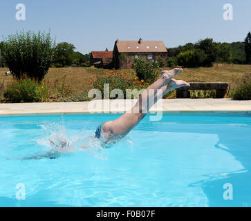 Jeune femme de plonger dans une piscine en vacances dans un gîte à Frayssinet-le-gelat dans le Lot Région Département de France Banque D'Images