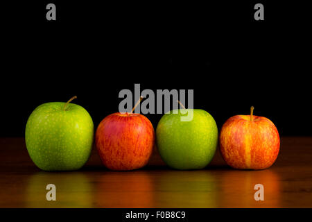 4 pommes rouge et vert sur un fond noir Banque D'Images