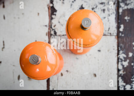 Salières et poivrières Orange sur une vieille table Banque D'Images