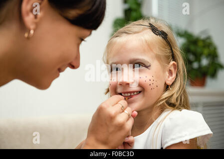 Femme peint le visage d'un enfant pour les vacances Banque D'Images