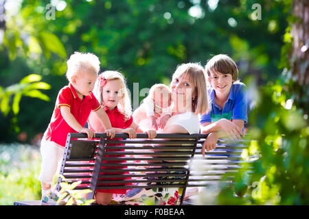 Grand-mère et ses petits-enfants profiter de pique-nique dans un parc. Grand-mère jouant avec des enfants dans une forêt ensoleillée d'automne Banque D'Images