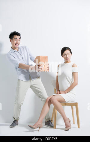 Young man giving girlfriend un cadeau Banque D'Images