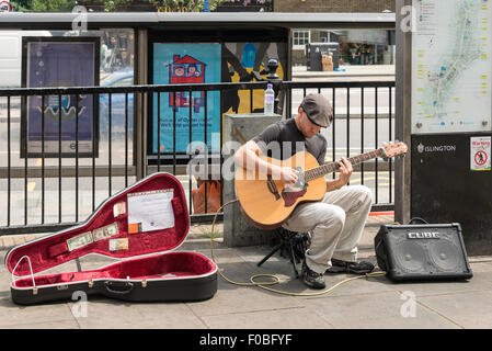 Busker rue à jouer de la guitare, Islington High Street, Islington, London Borough of Islington, Londres, Angleterre, Royaume-Uni Banque D'Images