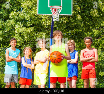 Garçon avec son équipe à l'origine au cours de jeu de basket-ball Banque D'Images