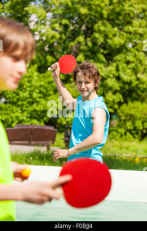 Deux smiling friends jouer ensemble ping pong Banque D'Images