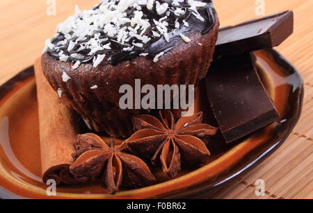 Des délicieux muffins au chocolat frais cuit avec noix de coco desséchée, morceaux de chocolat et l'anis étoilé se trouvant sur la plaque Banque D'Images