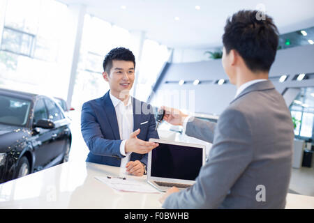 Jeune homme l'achat car in showroom Banque D'Images