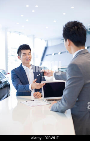 Jeune homme l'achat car in showroom Banque D'Images