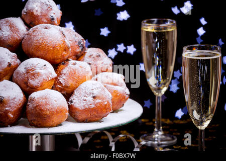 "Oliebollen", des pâtisseries pour le nouvel an et deux verres de champagne. Banque D'Images