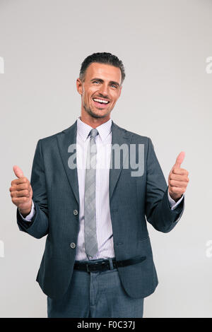 Portrait of a smiling woman showing Thumbs up isolé sur fond blanc Banque D'Images
