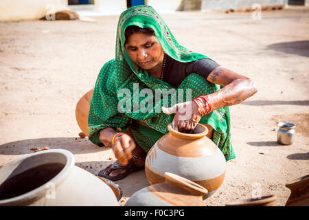 Potter's femme décorant les pots traditionnels dans la partie ancienne de Khajuraho, Madhya Pradesh, Inde Banque D'Images