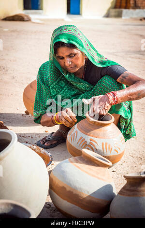 Potter's femme décorant les pots traditionnels dans la partie ancienne de Khajuraho, Madhya Pradesh, Inde Banque D'Images