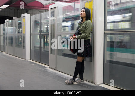 Femme se tient dans le métro s'appuya contre la barrière Banque D'Images