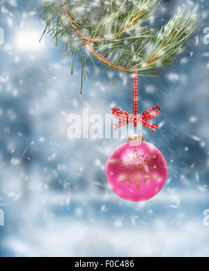 Décoration d'arbre de Noël traditionnel suspendu à une branche d'arbre avec une scène de la neige fond. Banque D'Images