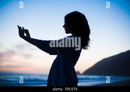 Woman on beach at sunset selfies, Malibu, California, USA Banque D'Images