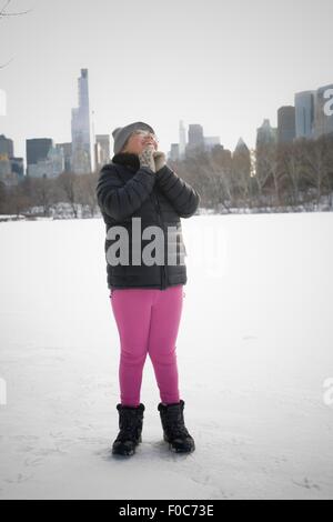Young Girl standing in snowy landscape, excité, New York, NY, USA Banque D'Images