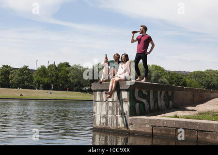 Multi-ethnic friends enjoying sur mur de retenue par canal Banque D'Images