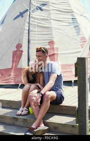 Happy young couple sitting on tipi structure tout en Maidstone Banque D'Images