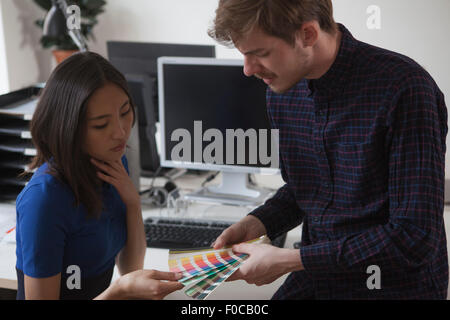Les jeunes hommes et les femmes des collègues d'affaires Choix de couleurs nuanciers dans office Banque D'Images