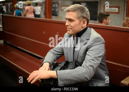 Berlin, Allemagne. Août 12, 2015. Une figure de cire de l'acteur américain George Clooney est assis sur un banc sur l'affichage à la station de métro à l'Alexanderplatz à Berlin, Allemagne, 12 août 2015, comme un événement promotionnel par Madame Tussauds. Dpa : Crédit photo alliance/Alamy Live News Banque D'Images