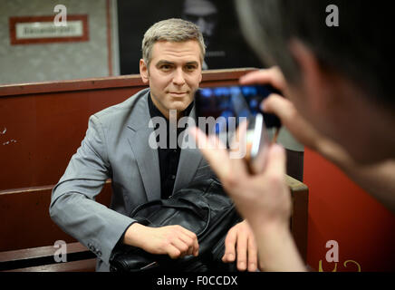 Berlin, Allemagne. Août 12, 2015. Une figure de cire de l'acteur américain George Clooney est assis sur un banc sur l'affichage à la station de métro à l'Alexanderplatz à Berlin, Allemagne, 12 août 2015, comme un événement promotionnel par Madame Tussauds. Dpa : Crédit photo alliance/Alamy Live News Banque D'Images