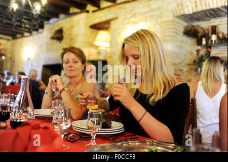 Teenage girl (15) au service d'une salade quercynoise traditionnelle de confit de canard foie gras de canard pate pruneaux et melon en France Banque D'Images