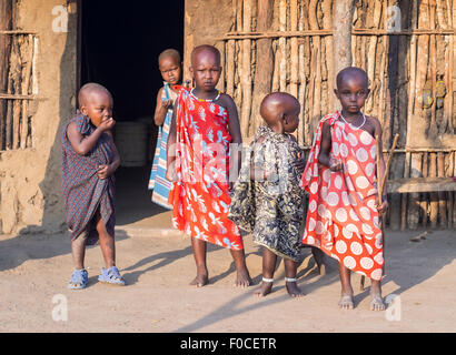 Enfants Massaïs en face d'une maison traditionnelle dans leur boma (village) en Tanzanie, Afrique Banque D'Images