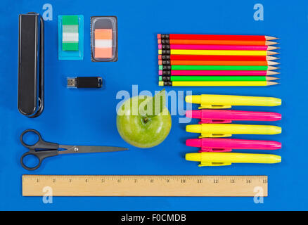 Retour à l'école ou de bureau Fournitures composé d'une pomme verte, mettre en évidence des marqueurs, agrafeuse, clé usb, règle, ciseaux, onglet mar Banque D'Images