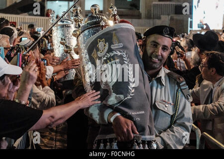 Jérusalem, Israël. 12 août, 2015. Rouleaux de la Torah sont transportés dans une cérémonie au mur occidental en tant que croyants fidèles tendre la main pour toucher et baiser entre eux. Soixante cinq rouleaux de la Torah, un don de communautés juives à travers le monde, ont été salué cérémonieusement au Mur occidental en commémoration des soldats des FDI ont diminué et les civils israéliens tués au cours de la 2014 Israel-Gaza Conflit, également connu sous le nom de l'opération. Credit : Alon Nir/Alamy Live News Banque D'Images