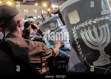 Jérusalem, Israël. 12 août, 2015. Rouleaux de la Torah sont transportés dans une cérémonie au mur occidental en tant que croyants fidèles tendre la main pour toucher et baiser entre eux. Soixante cinq rouleaux de la Torah, un don de communautés juives à travers le monde, ont été salué cérémonieusement au Mur occidental en commémoration des soldats des FDI ont diminué et les civils israéliens tués au cours de la 2014 Israel-Gaza Conflit, également connu sous le nom de l'opération. Credit : Alon Nir/Alamy Live News Banque D'Images