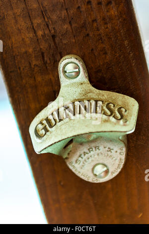 Un ouvre-bouteille Guiness on a wooden post Banque D'Images