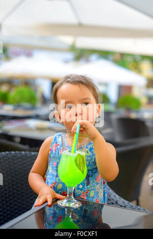 Petite fille est en train de boire de la limonade à la menthe à l'aide de la paille Banque D'Images