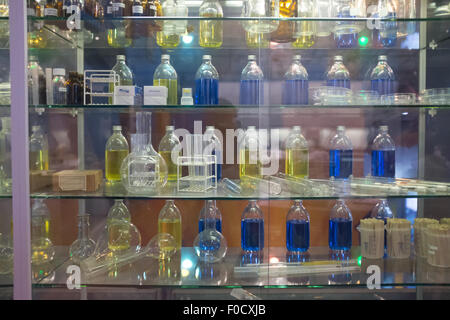 Bouteilles de produits chimiques dans un boîtier en verre dans un laboratoire Banque D'Images