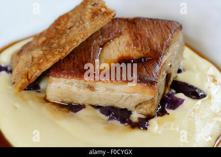 Flan de porc avec purée, chou rouge et un jus de pomme. Banque D'Images