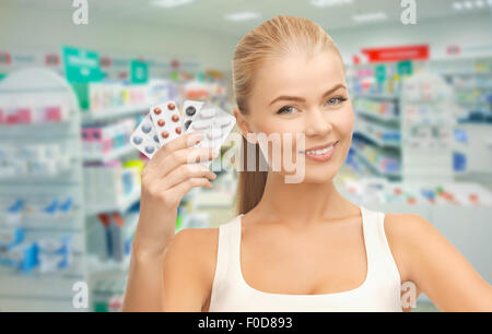 Jeune femme avec des comprimés en pharmacie ou pharmacie Banque D'Images