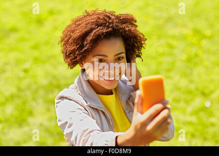 Happy african woman with smartphone selfies Banque D'Images