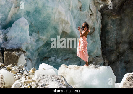 Un Sadhu, saint homme, est debout et priant sur un bloc de glace à Gaumukh, la principale source de la sainte gange, Gangotri Banque D'Images