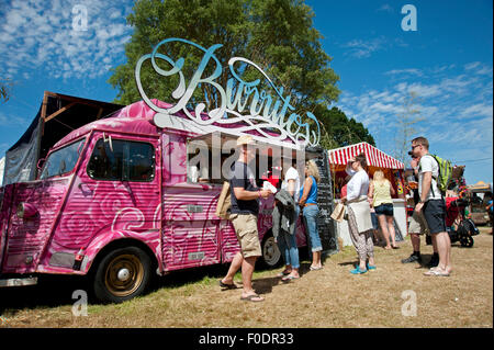 Festivaliers file d'attente pour les burritos à une cuisine mobile dans le soleil de l'été au Port Eliot Cornwall Festival Banque D'Images