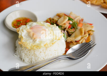 Feuilles de basilic frit riz cuit à la vapeur avec un mélange de fruits de mer et surmontée d'œuf frit Banque D'Images