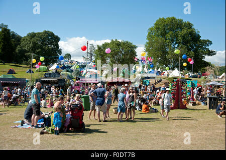 Les familles se réunissent autour de stands de nourriture et de tentes de l'événement dans le soleil d'été au Port Eliot Cornwall Festival Banque D'Images