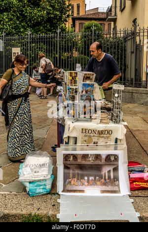 Homme vendant des cartes postales et des affiches de la dernière Cène de Léonard de Vinci devant l'église Santa Maria delle Grazie à Milan. Italie. Banque D'Images