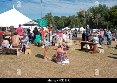 Les familles se réunissent autour de stands de nourriture et de tentes de l'événement dans le soleil d'été au Port Eliot Cornwall Festival Banque D'Images