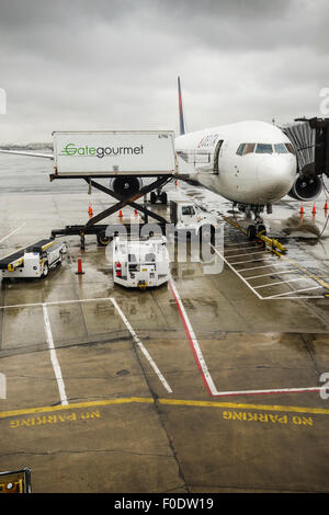 Ciel assombri sombre à l'Aéroport International Liberty de Newark, l'avion de Delta Airlines, service de traiteur, New Jersey USA. Banque D'Images