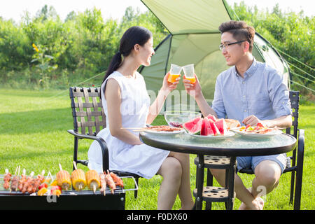 Jeune couple d'un barbecue en plein air Banque D'Images